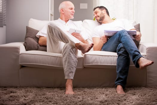 men reading on a sofa in a white living room in relax