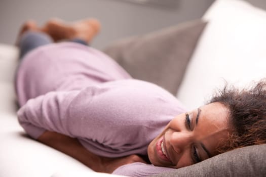 curly beautiful african-american woman lying on a sofa