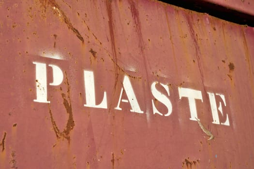 Lettering with the word Plaste (Plastic) on a container for collecting plastic waste at a disused factory in Germany