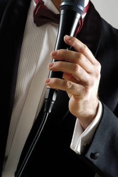 Mid section view of a singer holding a microphone