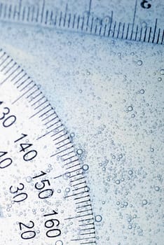 Close-up of a protractor and a ruler in water