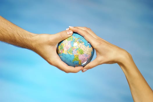 Close-up of a man and a womanŽs hands holding a globe