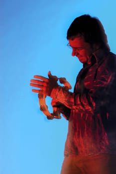 Side profile of a young man playing the tambourine