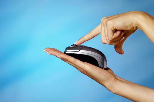 Close-up of a womanŽs finger pressing computer mouse on her hand