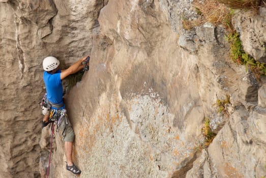 High angle view of a male rock climber hinging a rope on a rock