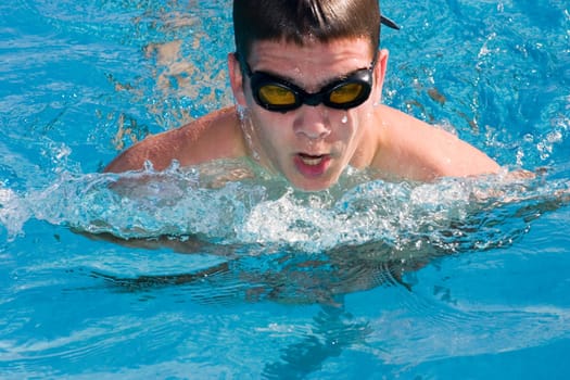 Close-up of a young man swimming in a swimming pool