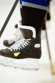Low section view of an ice hockey player with an ice hockey stick