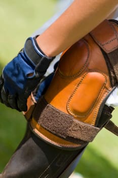 Close-up of a person tying a riding boot