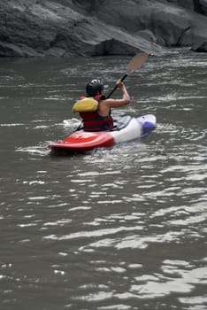 Rear view of a person kayaking in a river