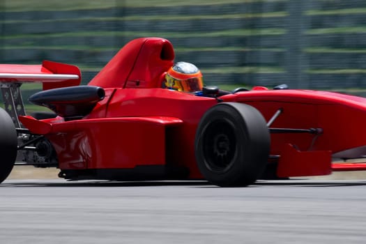 Person driving a formula one racing car on a motor racing track