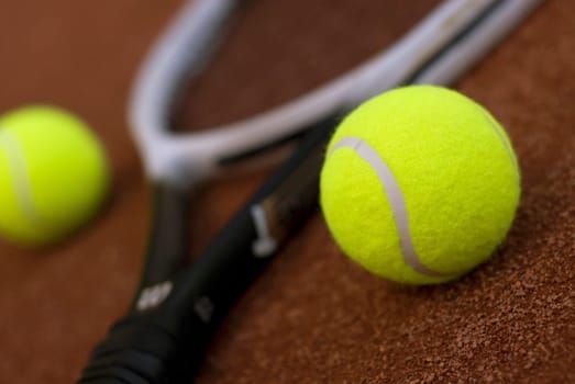 Close-up of two tennis balls and a tennis racket