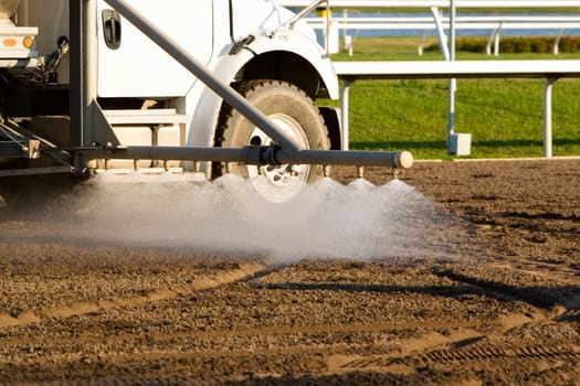 Truck spraying water on a horseracing track