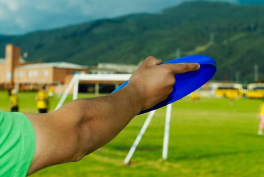 Close_up of a manŽs hand holding a plastic disc