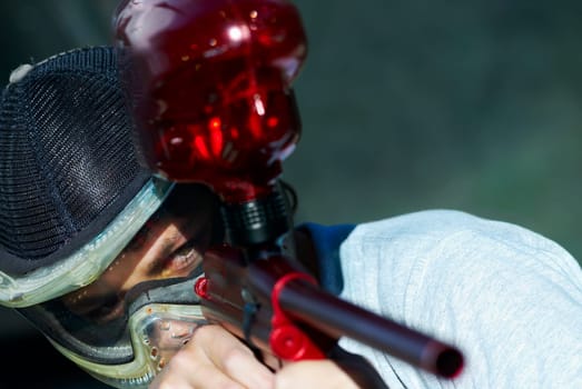Close_up of a man aiming with a paintball gun