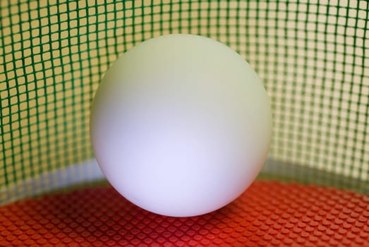 Close-up of a table tennis ball on a red table tennis racket