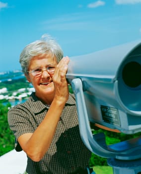 Portrait of a senior woman holding coin-operated binoculars and smiling, Bermuda
