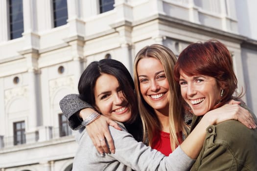 Close-up of a mid adult woman and two young women hugging