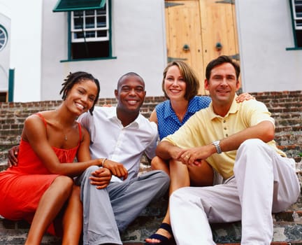 Portrait of two young couples sitting on steps and smiling, Bermuda