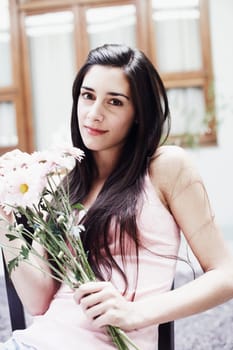 Portrait of a young woman holding a bunch of flowers