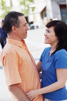Side profile of a mature man and a young woman standing face to face
