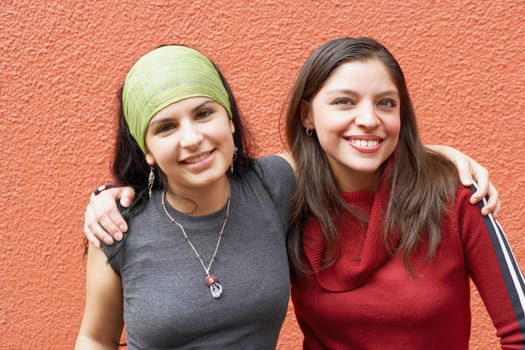 Portrait of two young women with their arms around each other