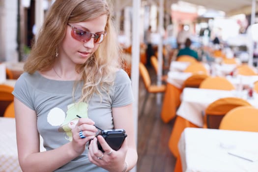Close-up of a young woman operating a personal data assistant