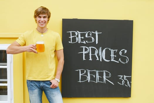 Portrait of a young man holding a glass of beer