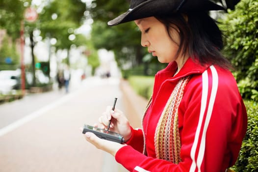 Side profile of a young woman holding a personal data assistant