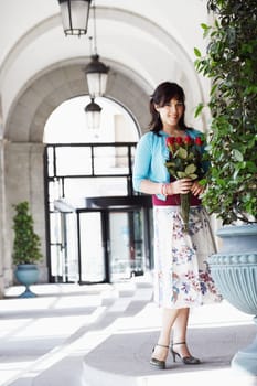 Portrait of a young woman holding a bunch of flowers
