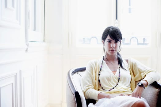 Portrait of a young woman sitting in an armchair