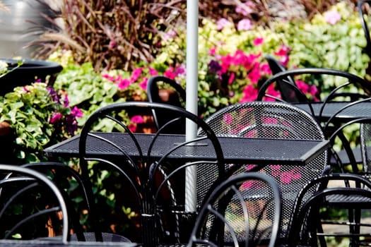 Close-up of tables and chairs at an outdoor cafe