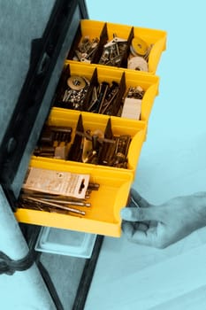 Close-up of a person pulling a drawer of a tool cabinet
