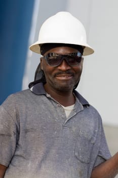 Close-up of a mature man with a pair of eyeglasses and a hardhat
