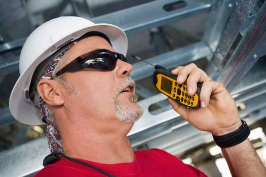 Close-up of a male construction worker talking on a walkie-talkie