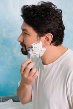 Side profile of a mid adult man shaving
