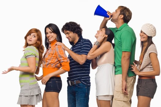 Side profile of a mid adult man shouting into a megaphone between his friends