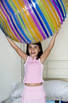 Close-up of a girl holding a large inflatable ball over her head