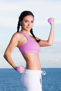 Portrait of a young woman exercising with dumbbells