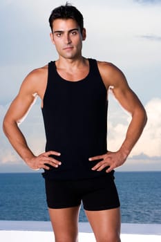Portrait of a young man standing with arms akimbo