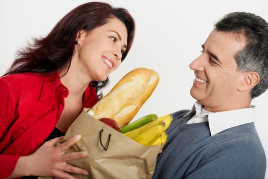 Close-up of a mid adult couple holding a shopping bag and smiling