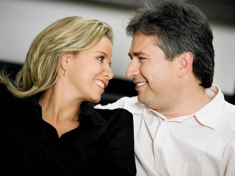 Close-up of a mid adult woman and a mature man looking at each other and smiling