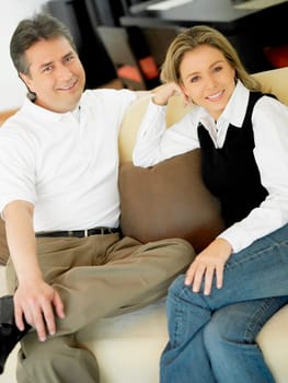 Portrait of a mature man and a mid adult woman sitting on a couch and smiling