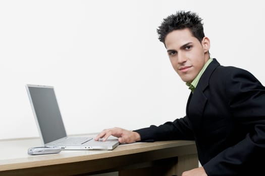 Portrait of a businessman sitting in front of a laptop