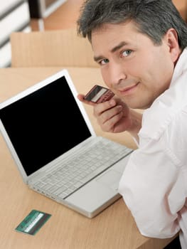 Portrait of a mature man holding a credit card