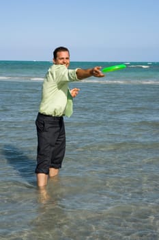 Mid adult man playing with a plastic disc on the beach