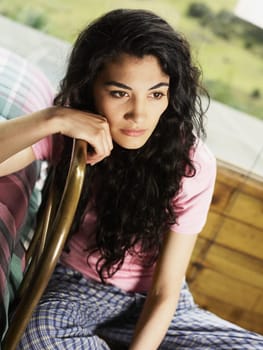 Young woman sitting on a chair and thinking