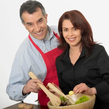 Portrait of a mid adult couple tossing salad