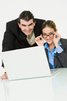 Portrait of a businessman and a businesswoman smiling in front of a laptop