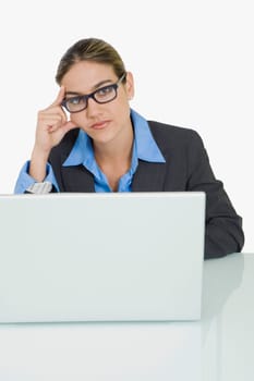 Portrait of a businessman sitting in front of a laptop and thinking