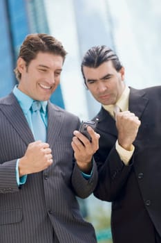 Two businessmen looking at a hand held device